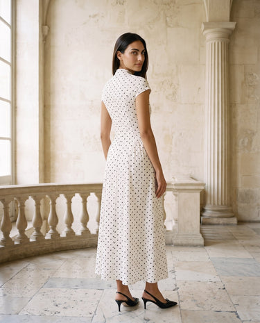 The Maura Polka Dot Dress in cream — polka dot maxi dress, side back view on model