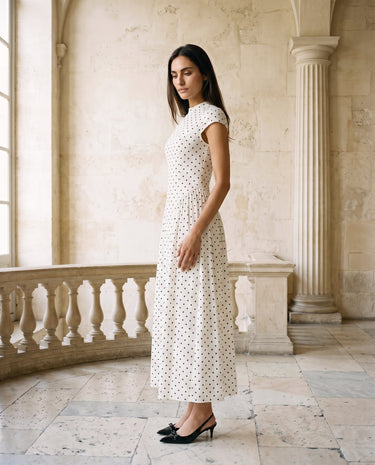 The Maura Polka Dot Dress in cream — polka dot maxi dress, side view on model