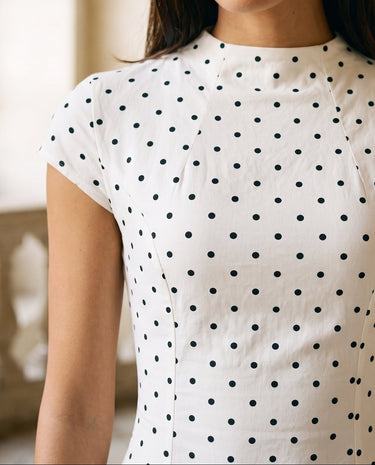 The Maura Polka Dot Dress in cream — close-up of the high neckline, cap sleeve and polka dot print