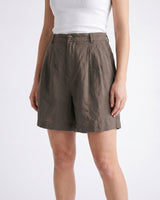 The Mauria Linen Shorts in cocoa — pleated linen shorts, side view on model