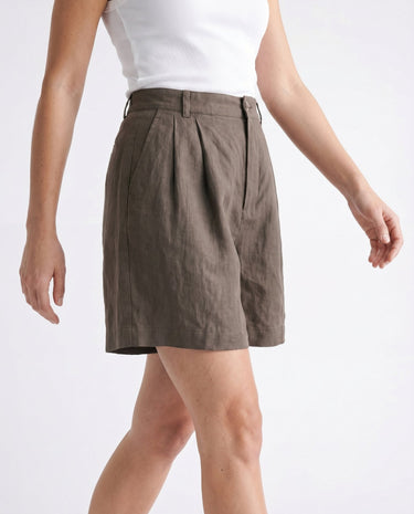 The Mauria Linen Shorts in cocoa — pleated linen shorts, walking view on model