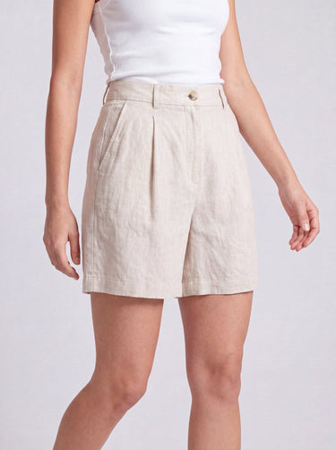 The Mauria Linen Shorts in oat — pleated linen shorts, walking view on model