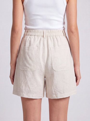 The Mauria Linen Shorts in oat — high-waisted pleated linen shorts, back view on model