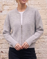 The Molly ribbed zip-up cardigan in gray — front view with hands together on model