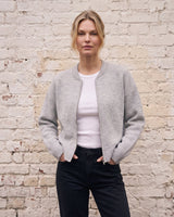 The Molly ribbed zip-up cardigan in gray — front view with hands in pockets on model