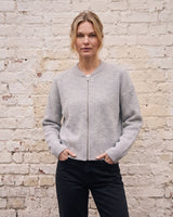 The Molly ribbed zip-up cardigan in gray — front view with hand in pocket on model