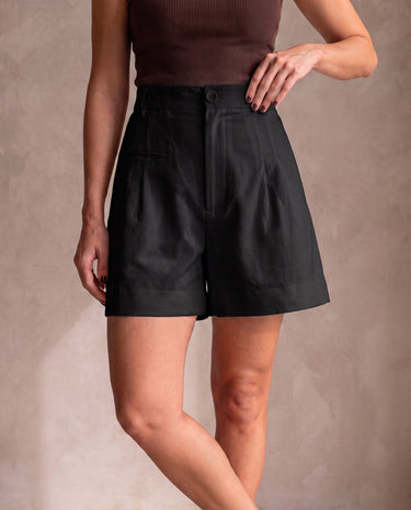 The Monroe short in black — front view with hand on hip on model