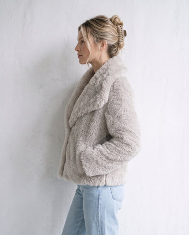 The Noa Faux Fur Coat in beige — faux fur coat, side view on model