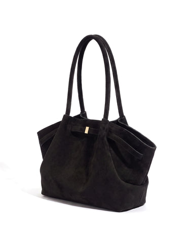 The Odette Suede Tote in black, three-quarter studio view on a pure white background with gold-tone keeper
