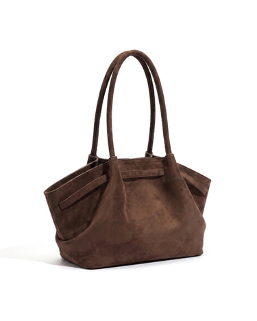 The Odette Suede Tote in brown, rear three-quarter view showing the suede strap band running across the back panel and through both wings