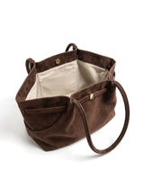 The Odette Suede Tote in brown, open top view showing the cream herringbone lining, interior slip pocket and gold-tone magnetic snap