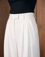 The Oriane pants in white — close-up of the high waist and front pleats