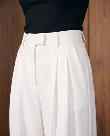 The Oriane pants in white — close-up of the high waist and front pleats