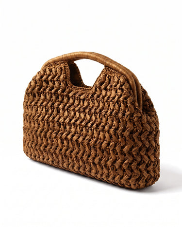 The Ravello Woven Clutch in turmeric, three-quarter studio view showing the woven body and top handle cut-out