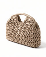 The Ravello Woven Clutch in beige, three-quarter studio view showing the woven body and top handle cut-out