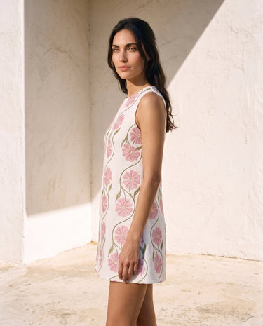 The Rosalie Floral Dress in pink — sleeveless floral mini dress, side view on model
