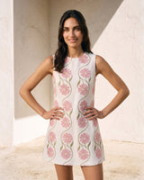 The Rosalie Floral Dress in pink — sleeveless floral mini dress, front view on model with hands on hips
