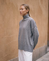 The Ruby sweater in stone — front three-quarter view on model