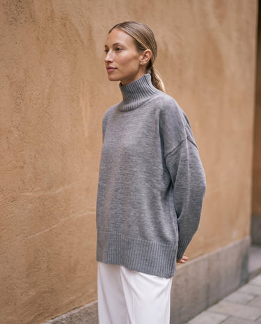 The Ruby sweater in stone — front three-quarter view on model