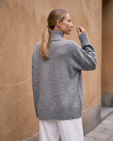 The Ruby sweater in stone — back view on model