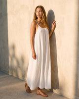 The Rylie Dress in white — gathered maxi dress with thin straps, three-quarter view on model