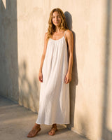 The Rylie Dress in white — gathered maxi dress with thin straps, standing front view on model