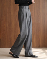 The Sabine tailored trousers in gray — side view showing the wide-leg drape on model