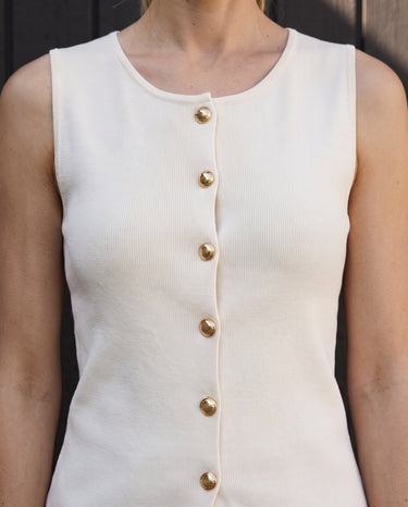 Close-up of the vest's round neckline and gold button placket – Moriel Heritage