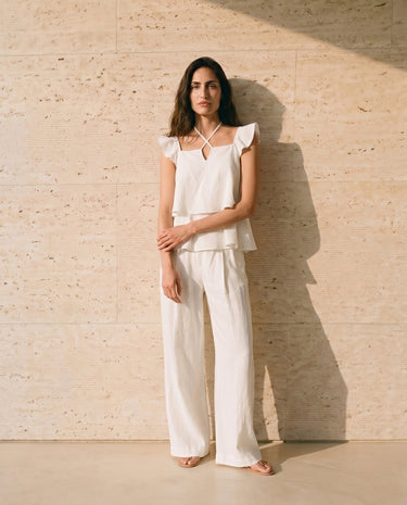 The Seraphine Cotton Set in white — flutter-sleeve top and wide-leg trousers, front styling view on model