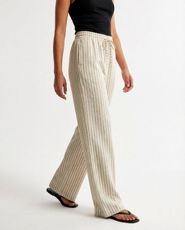 The Seville Stripe Drawstring Pant in brown stripe — striped wide-leg trousers, side view on model