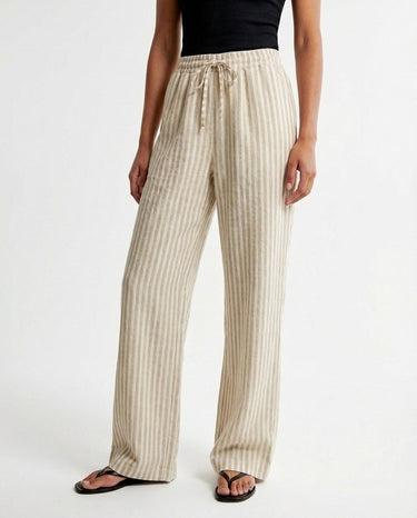 The Seville Stripe Drawstring Pant in brown stripe — striped wide-leg trousers, three-quarter view on model