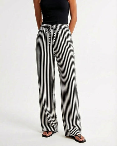 The Seville Stripe Drawstring Pant in black stripe — striped wide-leg trousers, front styling view on model