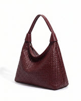 The Siren Woven Bag in burgundy, three-quarter studio view showing the slouched hobo silhouette