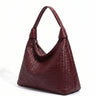 The Siren Woven Bag in burgundy, three-quarter studio view showing the slouched hobo silhouette