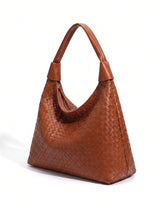 The Siren Woven Bag in caramel, three-quarter studio view showing the woven body and knotted strap