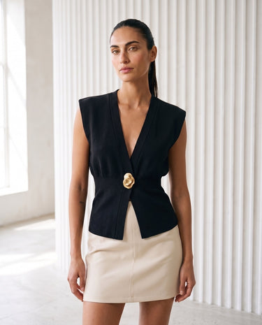 The Solara Gold Button Vest in black — sleeveless knit vest with deep V neck, front view on model