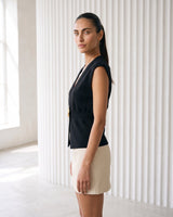 The Solara Gold Button Vest in black — sleeveless knit vest, side view on model