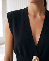 The Solara Gold Button Vest in black — close-up of the deep V neckline and sculptural gold button