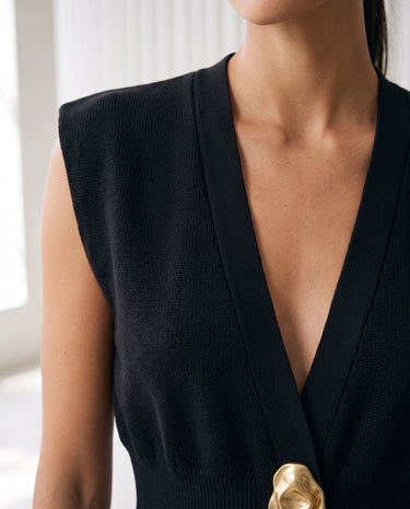 The Solara Gold Button Vest in black — close-up of the deep V neckline and sculptural gold button