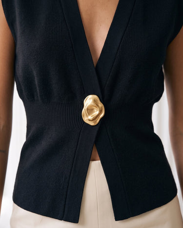 The Solara Gold Button Vest in black — close-up of the gold button and open front