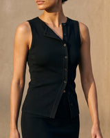 Close front view of the black top's asymmetric button placket and folded lapel – Moriel Heritage