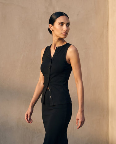 Model wearing the black sleeveless top with a matching skirt, front view – Moriel Heritage