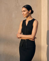 Model with arms crossed wearing the black sleeveless top, three-quarter view – Moriel Heritage