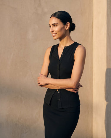 Model with arms crossed wearing the black sleeveless top, three-quarter view – Moriel Heritage