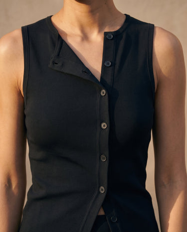 Close-up of the black top's folded lapel detail and button placket – Moriel Heritage