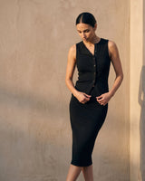 Model looking down in the black sleeveless top and skirt, full length – Moriel Heritage