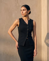 Side view of the black sleeveless top with hand on hip – Moriel Heritage