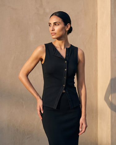 Side view of the black sleeveless top with hand on hip – Moriel Heritage