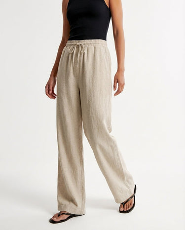 The Verena Cotton Linen Trousers in beige — wide-leg trousers, side view on model
