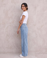 The Tiela Adjustable Jeans in blue — wide-leg jeans, side view on model